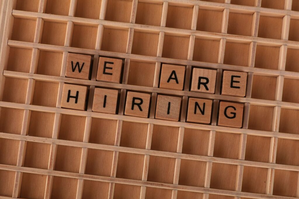 Wooden tiles on a board forming the phrase 'We Are Hiring', ideal for job announcements.