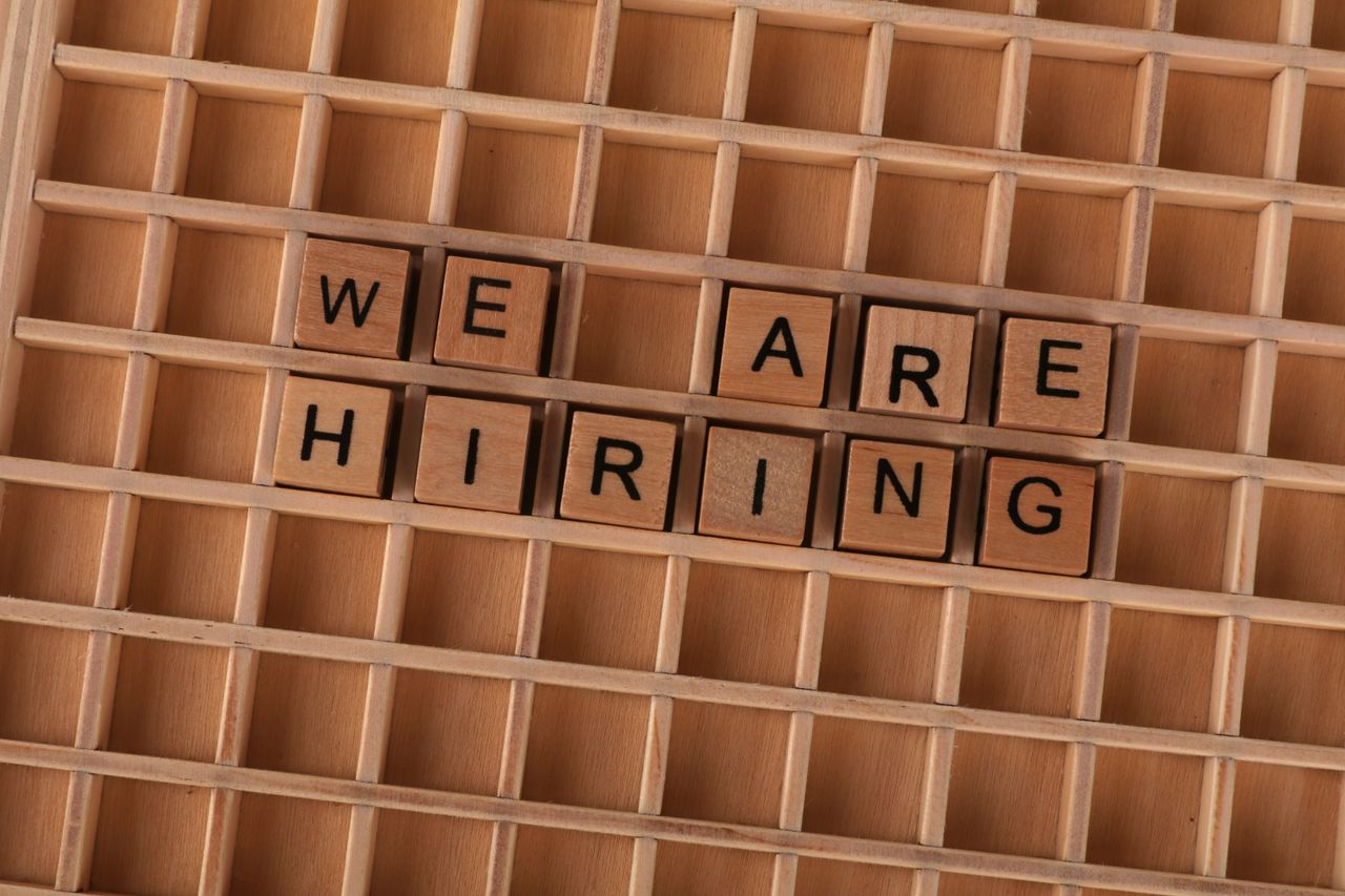 Wooden tiles on a board forming the phrase 'We Are Hiring', ideal for job announcements.